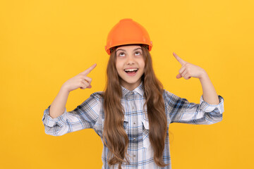 happy teen girl pointing finger on helmet in checkered shirt, protection