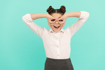 Fototapeta premium Pretending to be superhero. Happy schoolgirl make fingers eyeglasses. Pretend play. Imaginative play