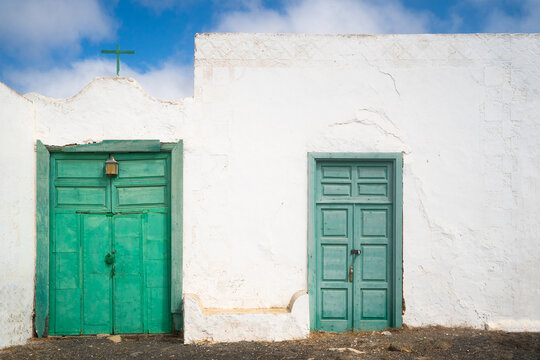 Traditional Facade With Two Green Doors And Cross.