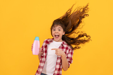 happy teen girl with long curly hair hold shampoo bottle, keratin