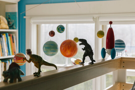 Toy Dinosaur Figures in Bedroom of Child with rocket ship