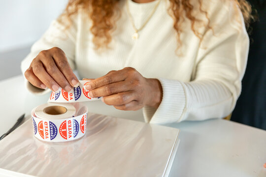 Woman Tearing I Voted Stickers