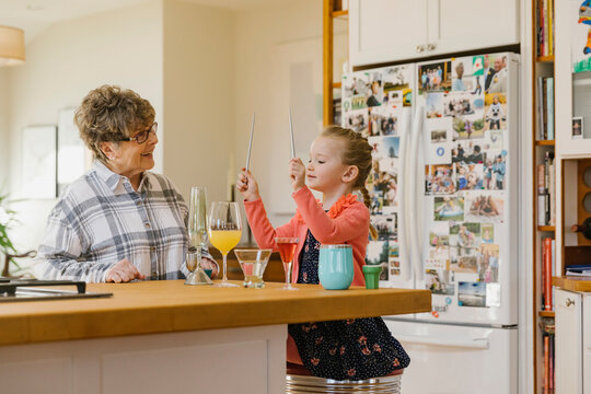 Cute young Girl Playing Drums on Glassware at Home