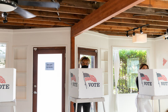 Diverse Voters In Booths Wearing Masks