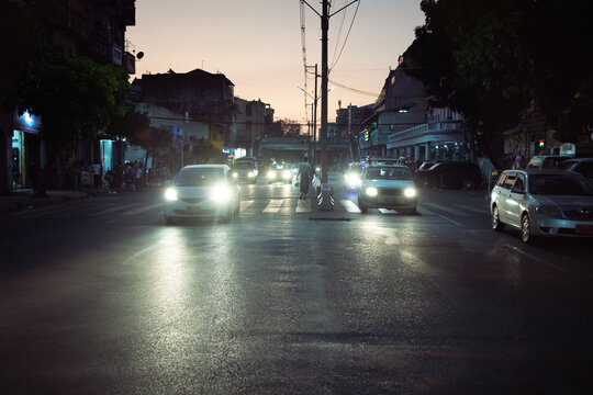 Man walking at sunset in the middle of busy road
