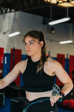 Muscular sportswoman using exercise machine