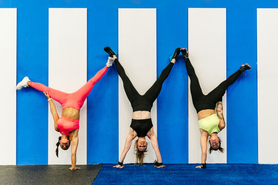 Sportswomen doing handstand near wall