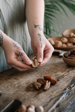 Tattooed Woman Cutting Dates For Organic Cocoa Energy Balls
