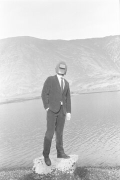 conceptual portrait of a man in a suit and mask