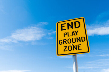 End play ground zone yellow traffic road sign and black letters under bright blue sky background with copy space for text