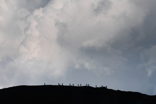 silhouettes of hikers walking along the traverse