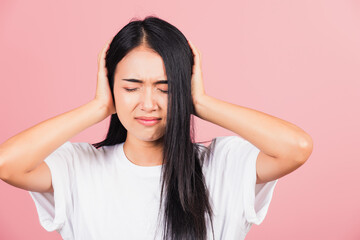 Asian portrait beautiful cute young woman have closed ears with hand palms and close eyes, studio...