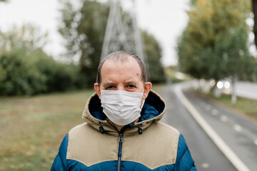 Senior man wearing disposable mask on the street