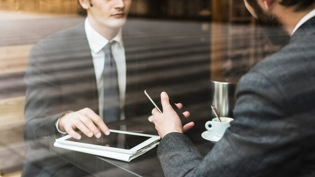 Businessmen working and talking at cafe in the city