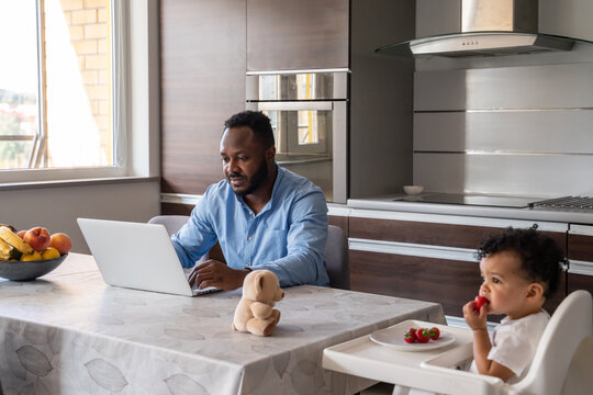 Dad Working While Daughter Eating Near