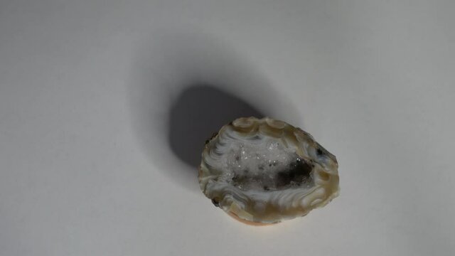 Beautiful glistening rock mineral gem stone spinning and rotating on white background shiny crystal Natural Quartz Amethyst cave geode