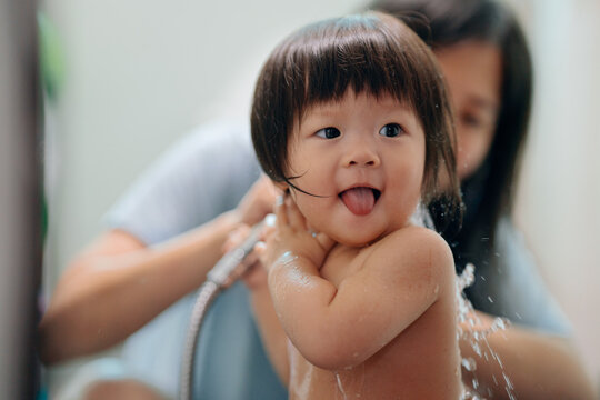 Mother helps little girl bath