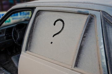 A dirty, unwashed car with a question mark in the dirt.