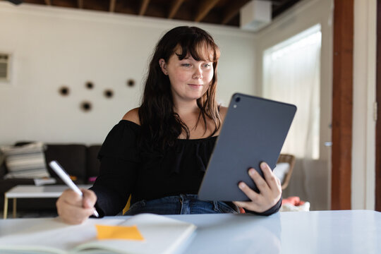 Woman Uses Tablet to Take an Online Class