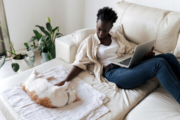 Black woman with laptop and cat