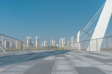 A modern pedestrian bridge in a park.