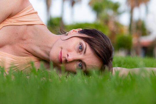 Portrait of a young woman lying in grass