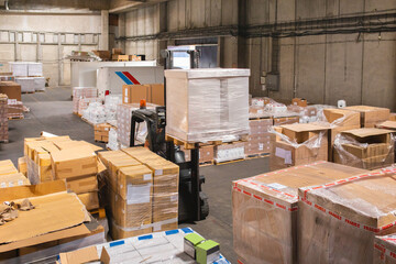 The worker transports freight using a forklift