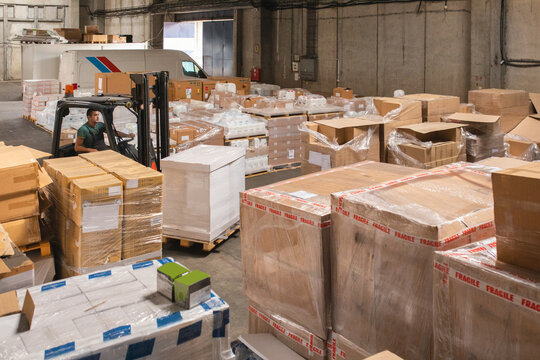 The worker transports freight using a forklift
