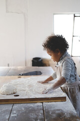 クッキー作りで生地を伸ばす女の子