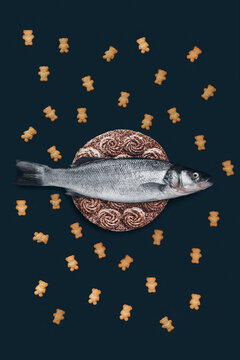 A fish on dark background with a cake and biscuits