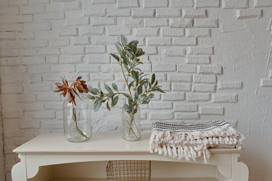 two glass vases on a brick background and a white table