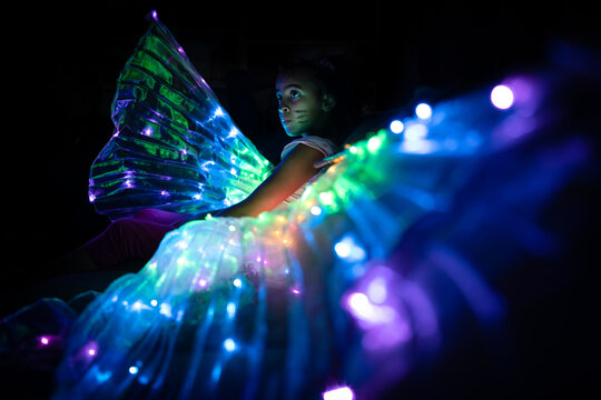Low angle photo girl in light-up LED wing costume