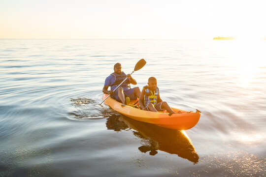 Father and son row to shore in kayak