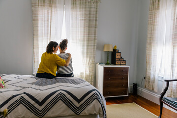 Mother and Teen Daughter talking in bedroom