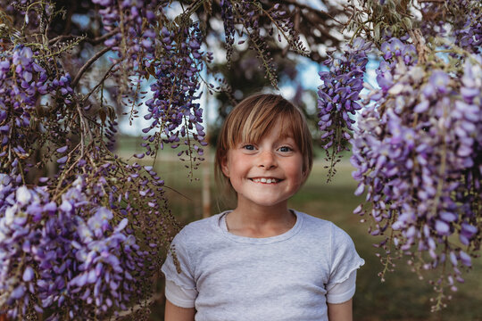 young girl standing in wisteria