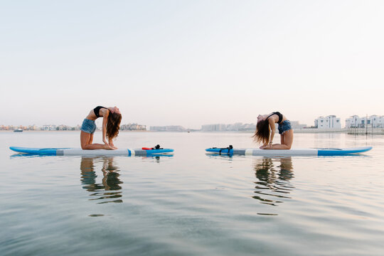 Women doing yoga on paddle boards
