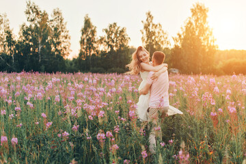 a couple in love walks through a flower meadow. Love and spring blooming. a man embraces a woman - Powered by Adobe