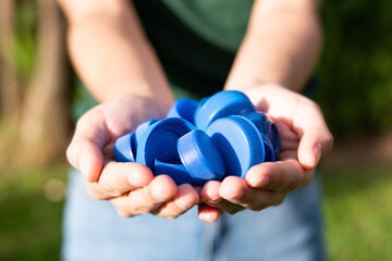 Recycling, a person holding plastic bottle caps with two hands