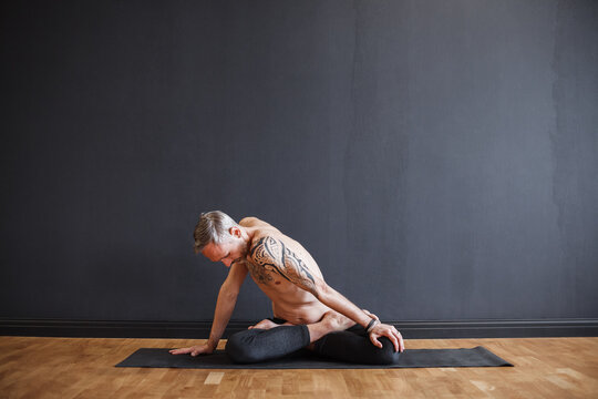 Mature man doing Seated Twist on mat