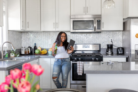 Woman Uses Her Tablet In the Kitchen