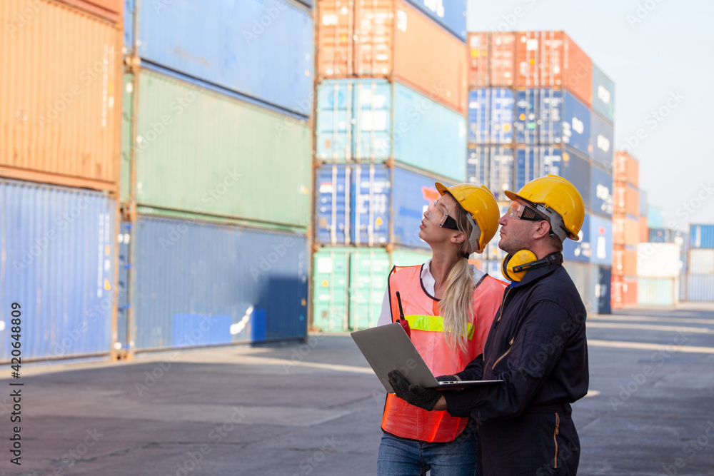 Poster working engineer in the construction container yard. worker and supervisor checking containers data.