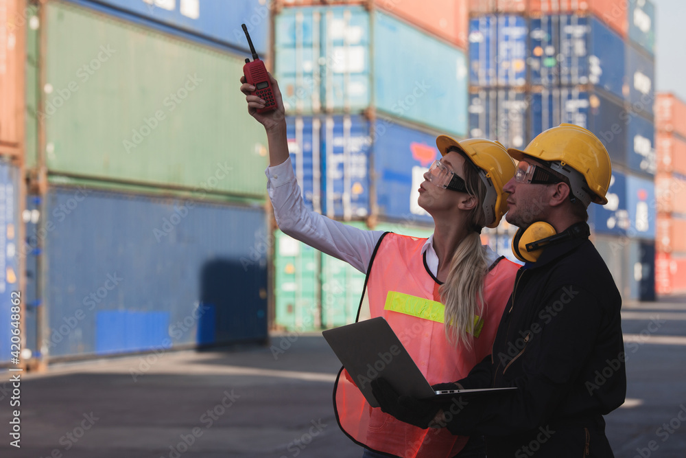Poster working engineer in the construction container yard. worker and supervisor checking containers data.