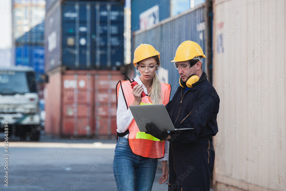 Poster working engineer in the construction container yard. worker and supervisor checking containers data.