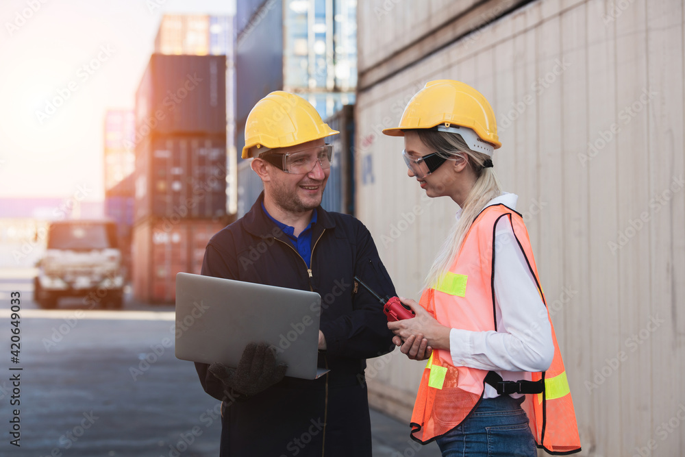 Poster working engineer in the construction container yard. worker and supervisor checking containers data.