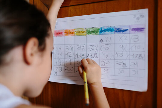 Kid writing on handmade month calendar