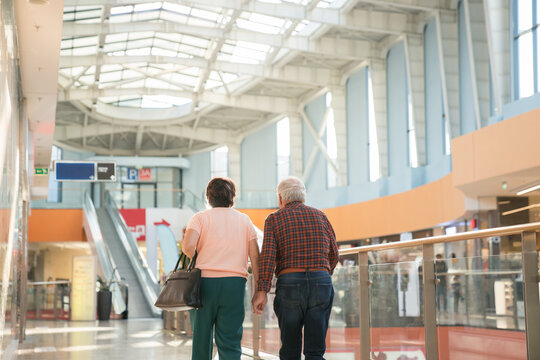 Senior Couple Walking At Shopping Mall - Powered by Adobe