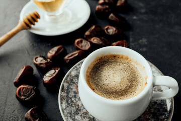 freshly brewed coffee with foam, dried dates on vintage dishes oriental in dark atmosphere.Suhur morning snack in the fast of Ramadan. selective focus