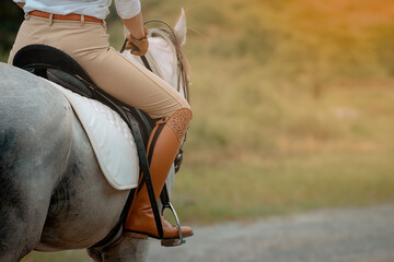 Woman riding on a brown horse outdoor in farm.