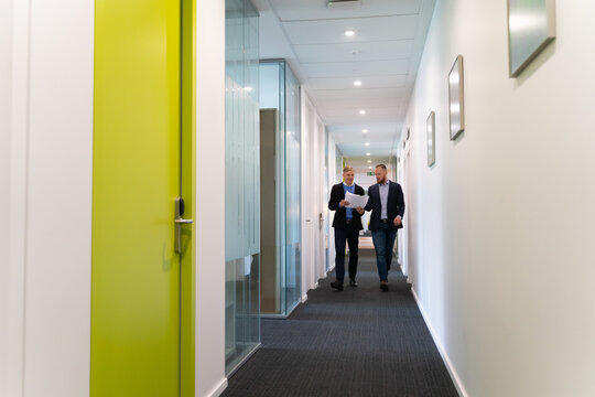 Colleagues Walking At Office Corridor