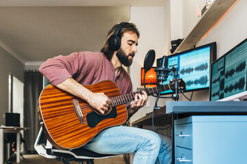 Young man recording music at home music studio